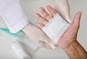 Clinician dressing a wound on a hand